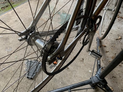Loosen the rear axle to create just enough clearance to take the belt from the sprockets